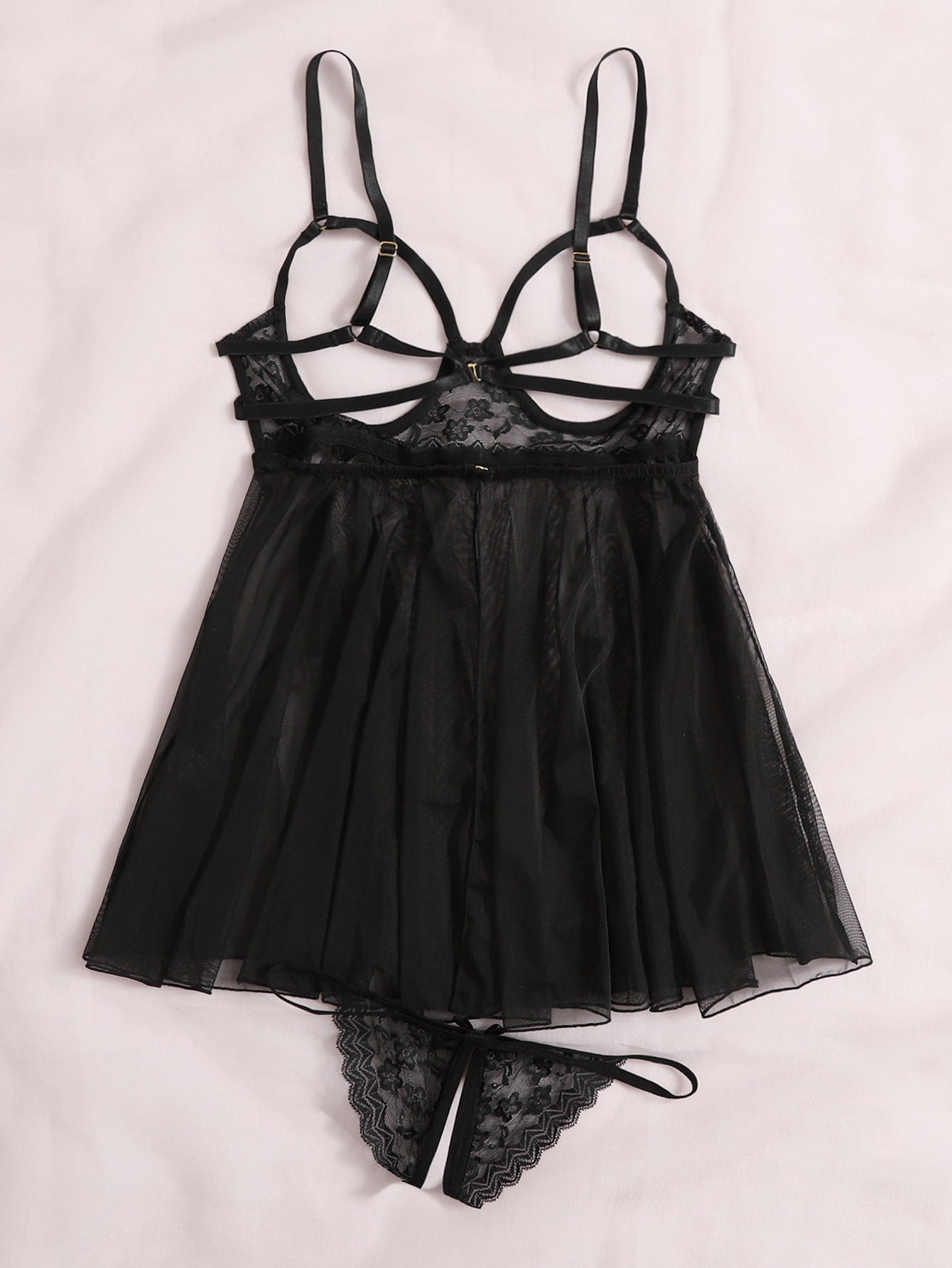 Women's black sheer mesh babydoll lingerie set with cut-out detail, adjustable spaghetti straps, triangle cups, and matching low-rise thong.