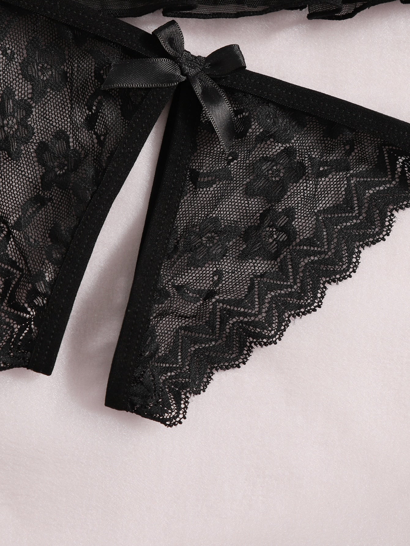 Women's black sheer mesh babydoll lingerie set with cut-out detail, adjustable spaghetti straps, triangle cups, and matching low-rise thong.