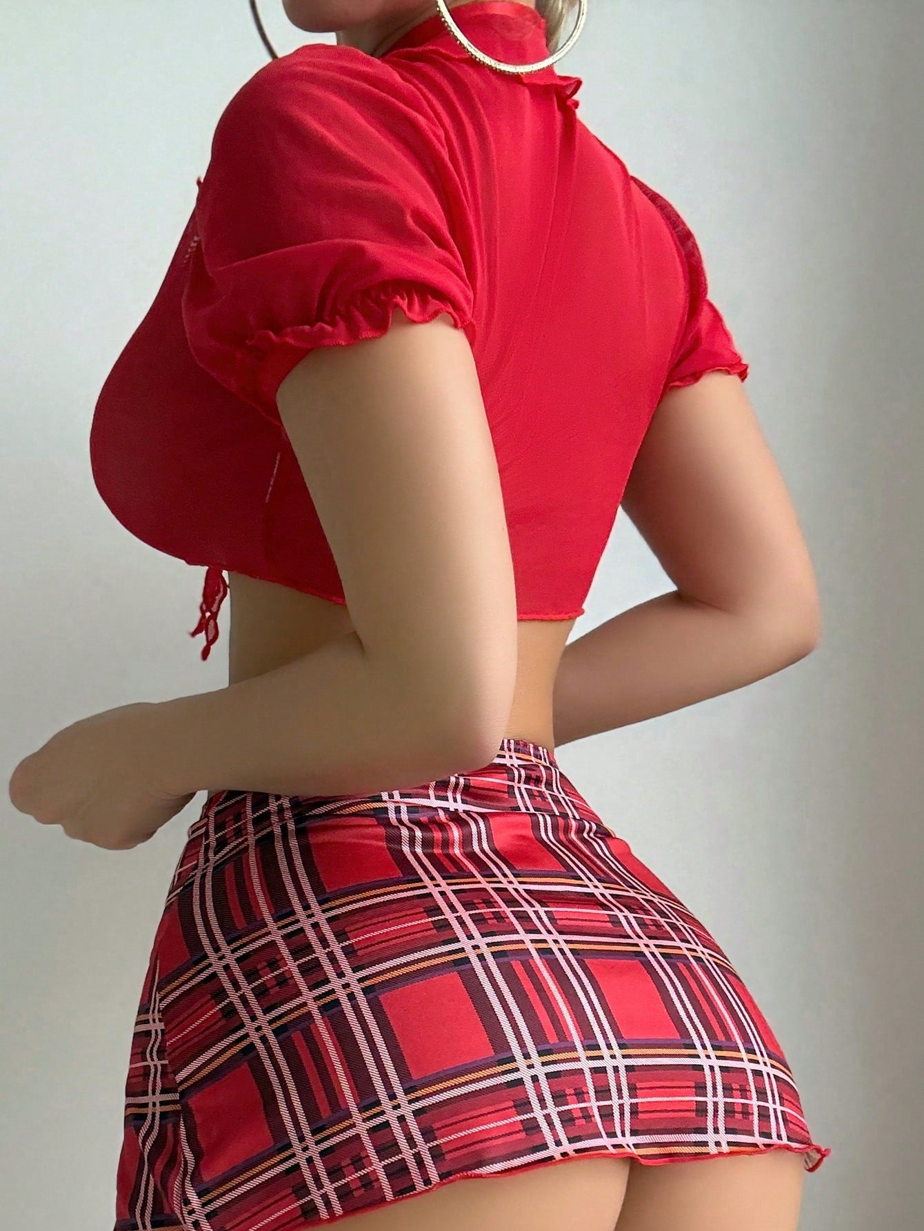 Women's red plaid Christmas schoolgirl lingerie costume set with strappy crop top, high-slit mini skirt, G-string, stockings, and choker