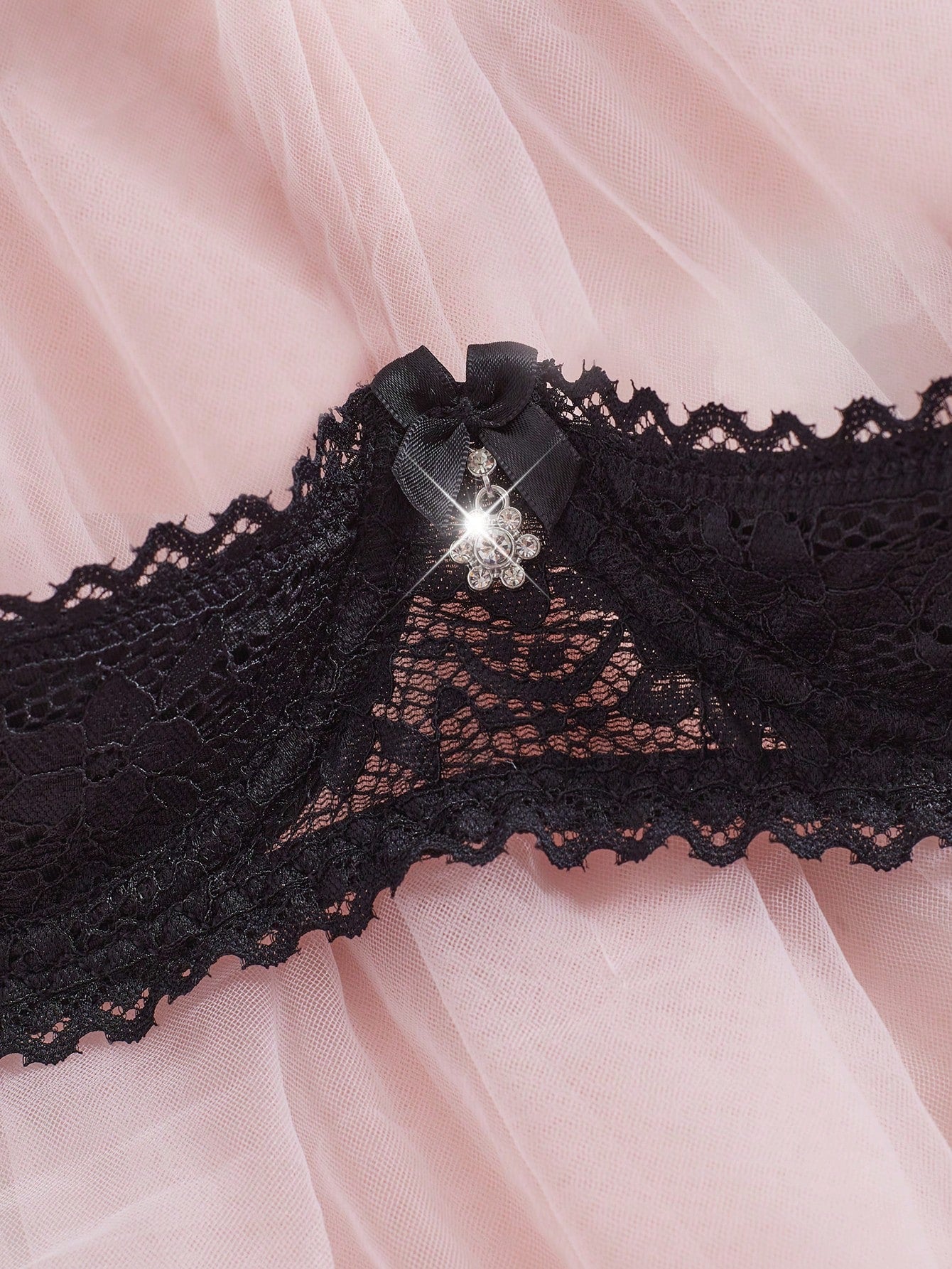Women's semi-sheer black lace underwire bra with adjustable spaghetti straps, contrast lace detail, 1/2 cup design, and pullover fit.