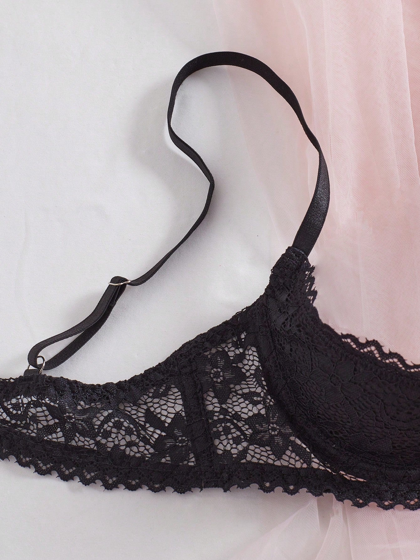 Women's semi-sheer black lace underwire bra with adjustable spaghetti straps, contrast lace detail, 1/2 cup design, and pullover fit.