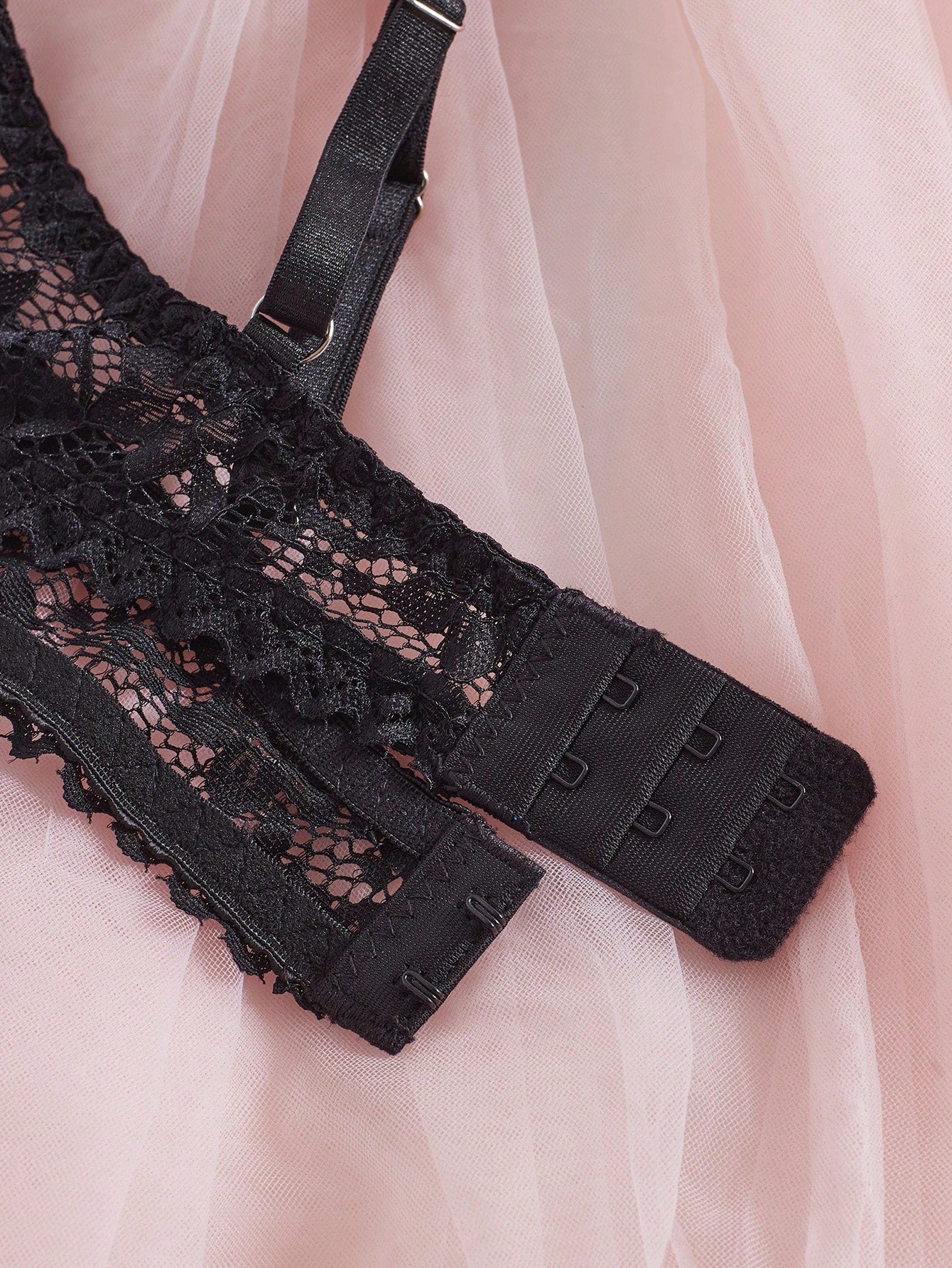 Women's semi-sheer black lace underwire bra with adjustable spaghetti straps, contrast lace detail, 1/2 cup design, and pullover fit.