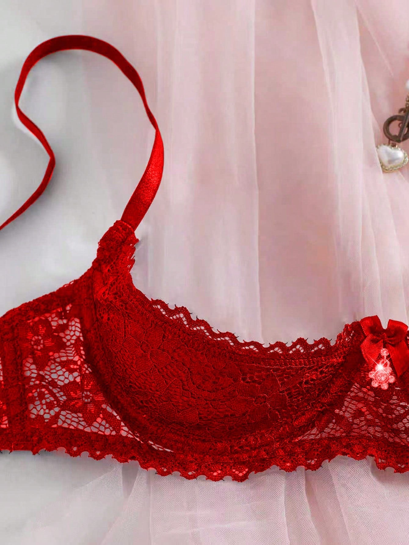 Women's semi-sheer black lace underwire bra with adjustable spaghetti straps, contrast lace detail, 1/2 cup design, and pullover fit.