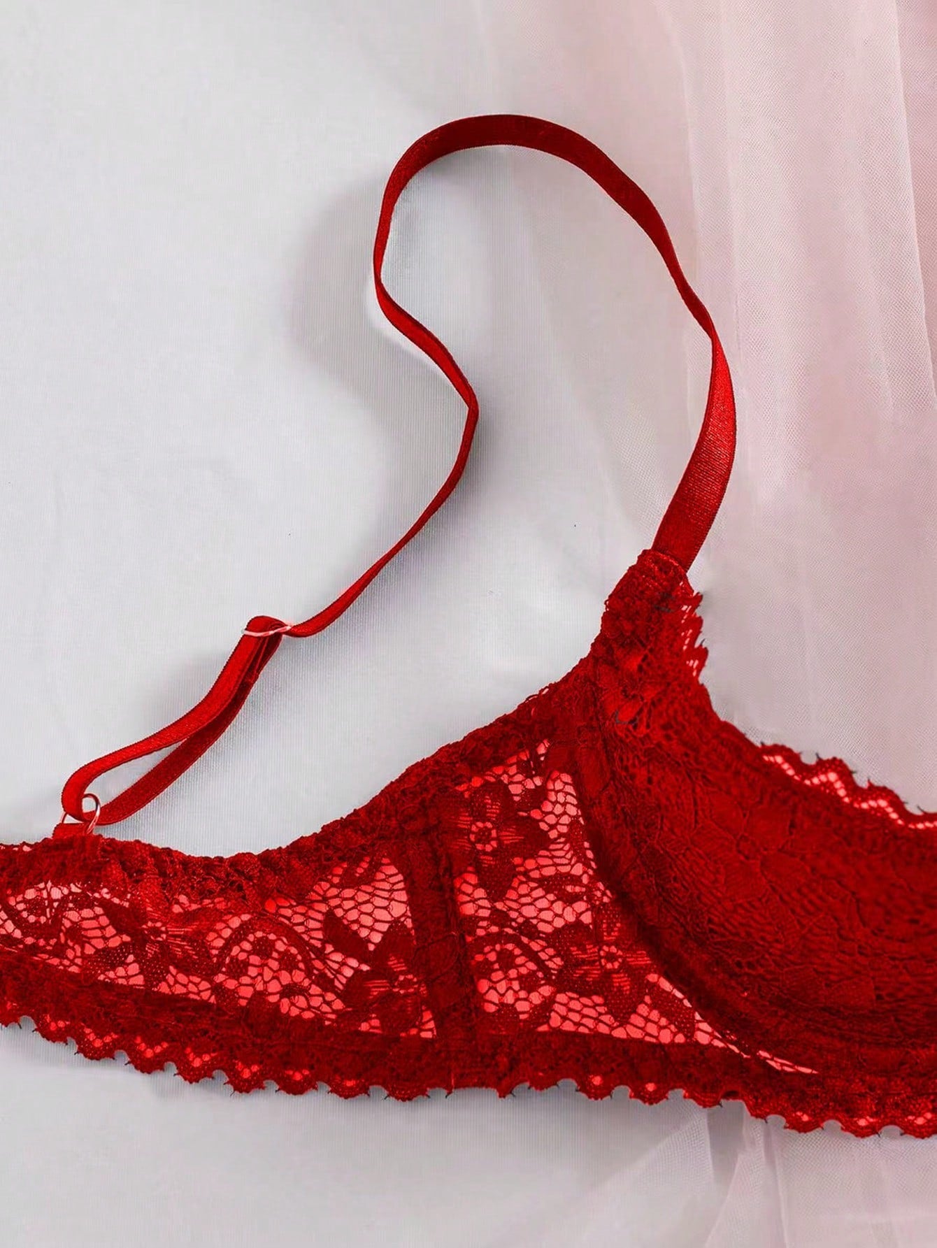 Women's semi-sheer black lace underwire bra with adjustable spaghetti straps, contrast lace detail, 1/2 cup design, and pullover fit.