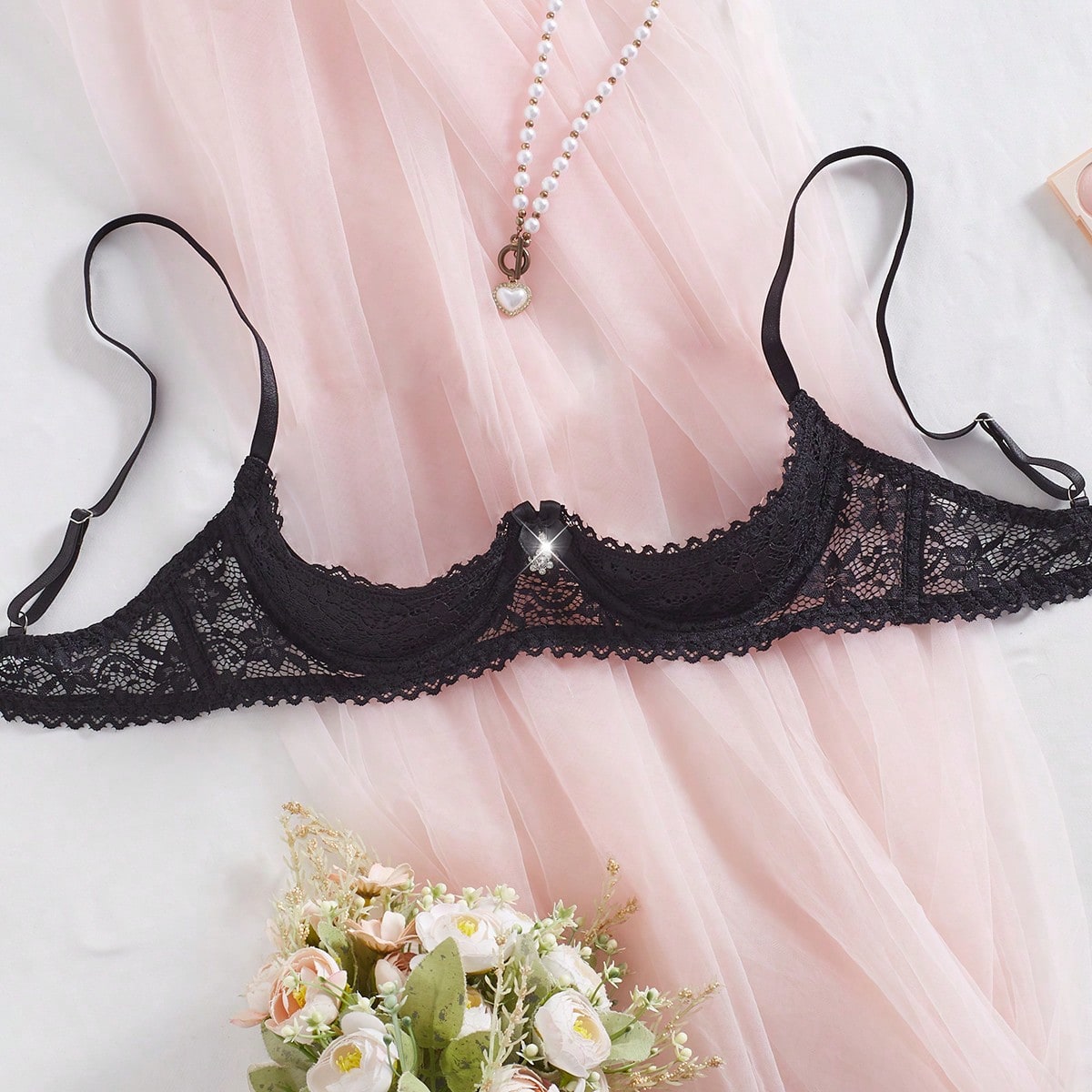 Women's semi-sheer black lace underwire bra with adjustable spaghetti straps, contrast lace detail, 1/2 cup design, and pullover fit.