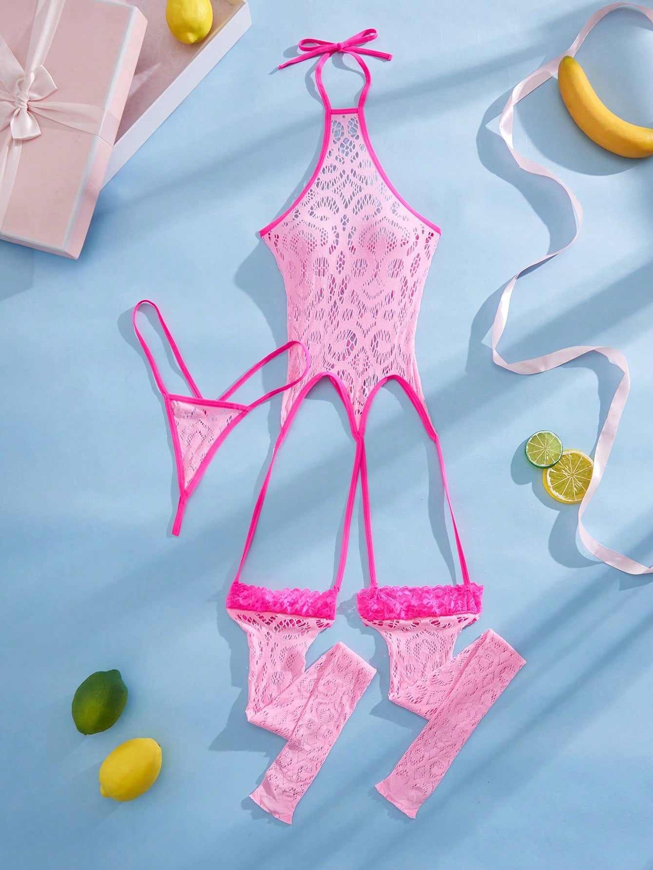Women's semi-sheer mesh lingerie bodysuit set with halter neckline, backless design, hollow out details, bow accent, and thong styling in pink colorblock fabric.