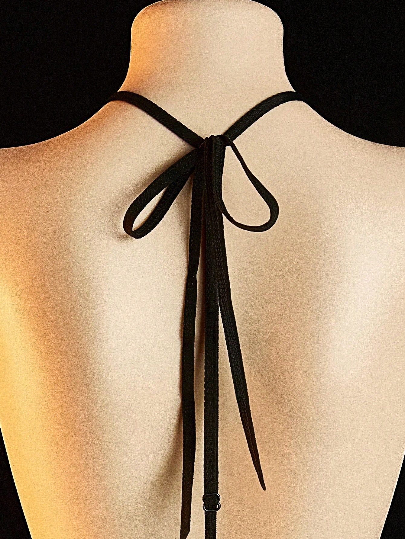 Women's sheer black lace bodysuit with backless design, halter neckline, and wireless one-piece fit in medium-stretch knitted fabric.
