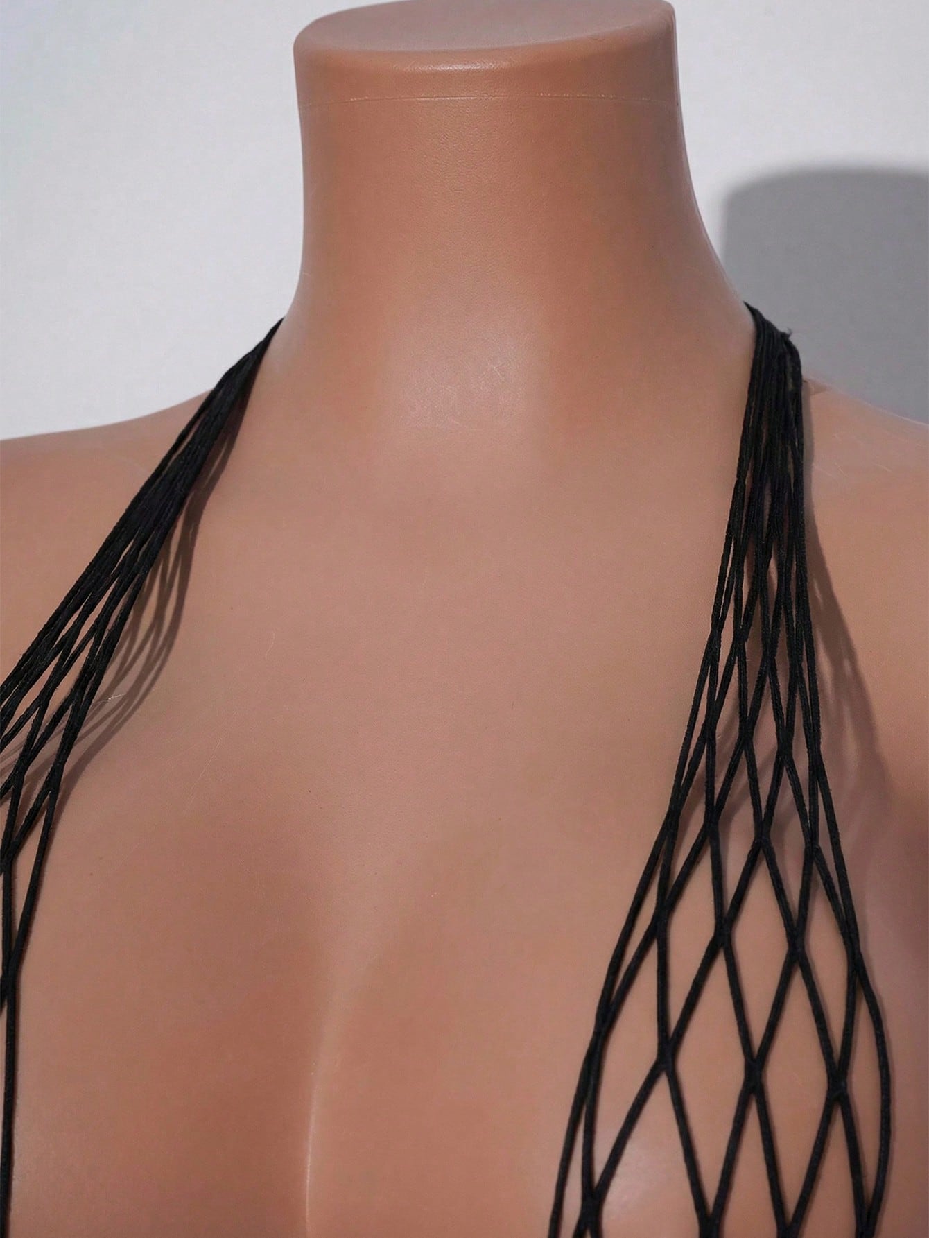 Women's burgundy sheer fishnet bodysuit with halter neckline, lace-up hollow out details, adjustable straps, and sleeveless Y2K styling.