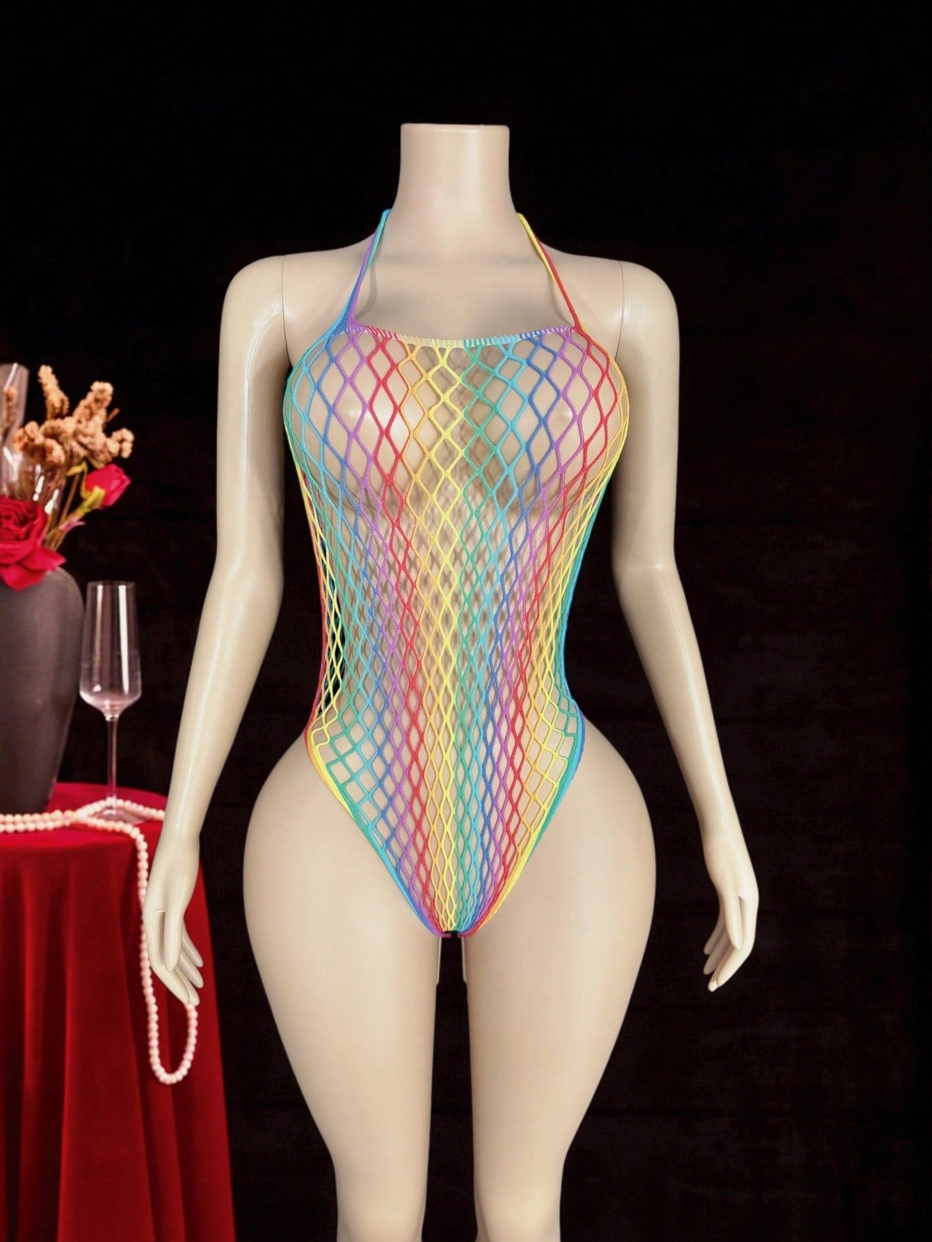 Women's sheer fishnet halter bodysuit with sleeveless design, backless tie-back detail, and high-stretch fabric in a wireless teddy style.