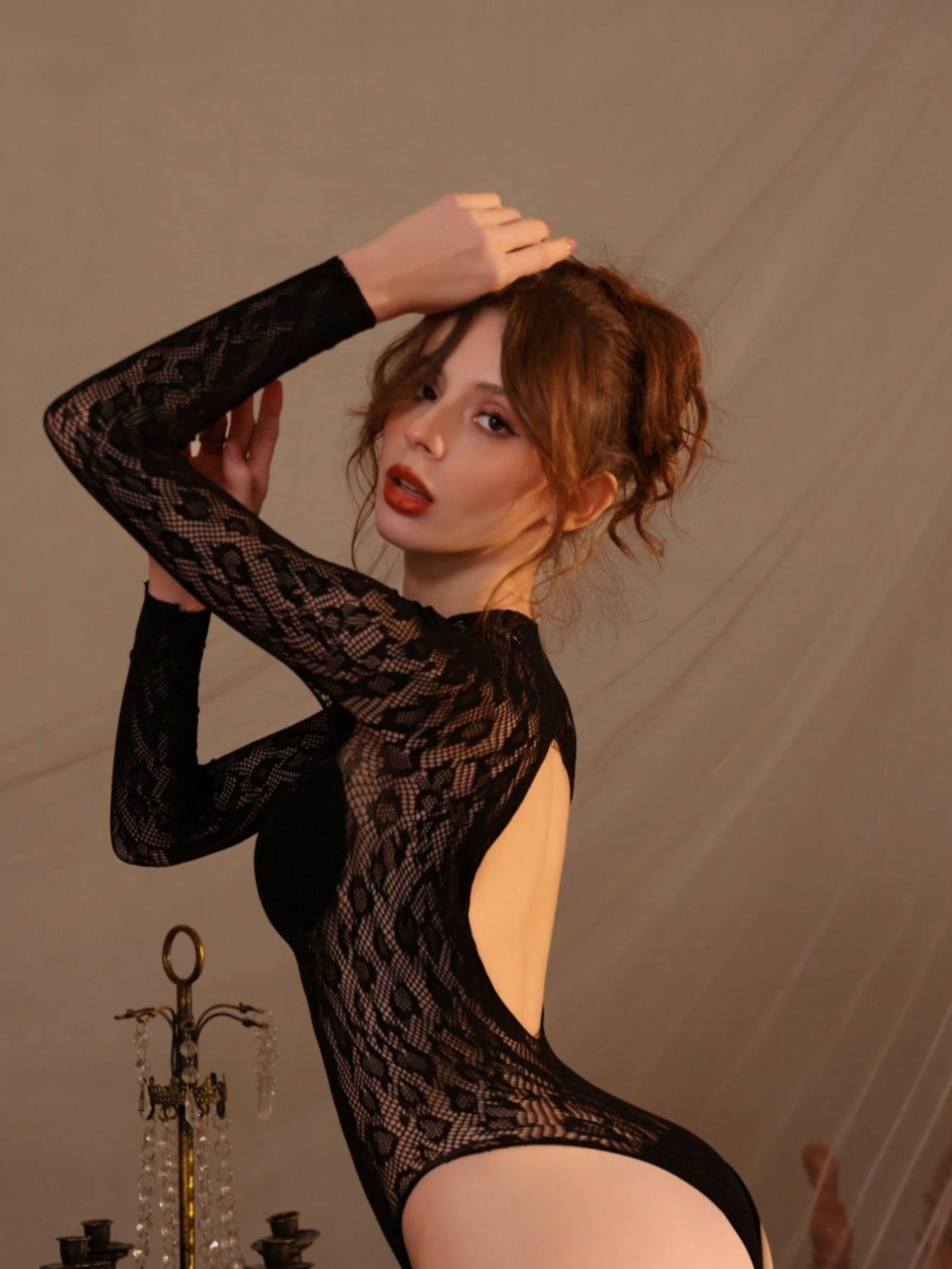 Women's black fishnet sheer bodysuit with adjustable straps, round neck, and high-stretch polyamide elastane fabric.