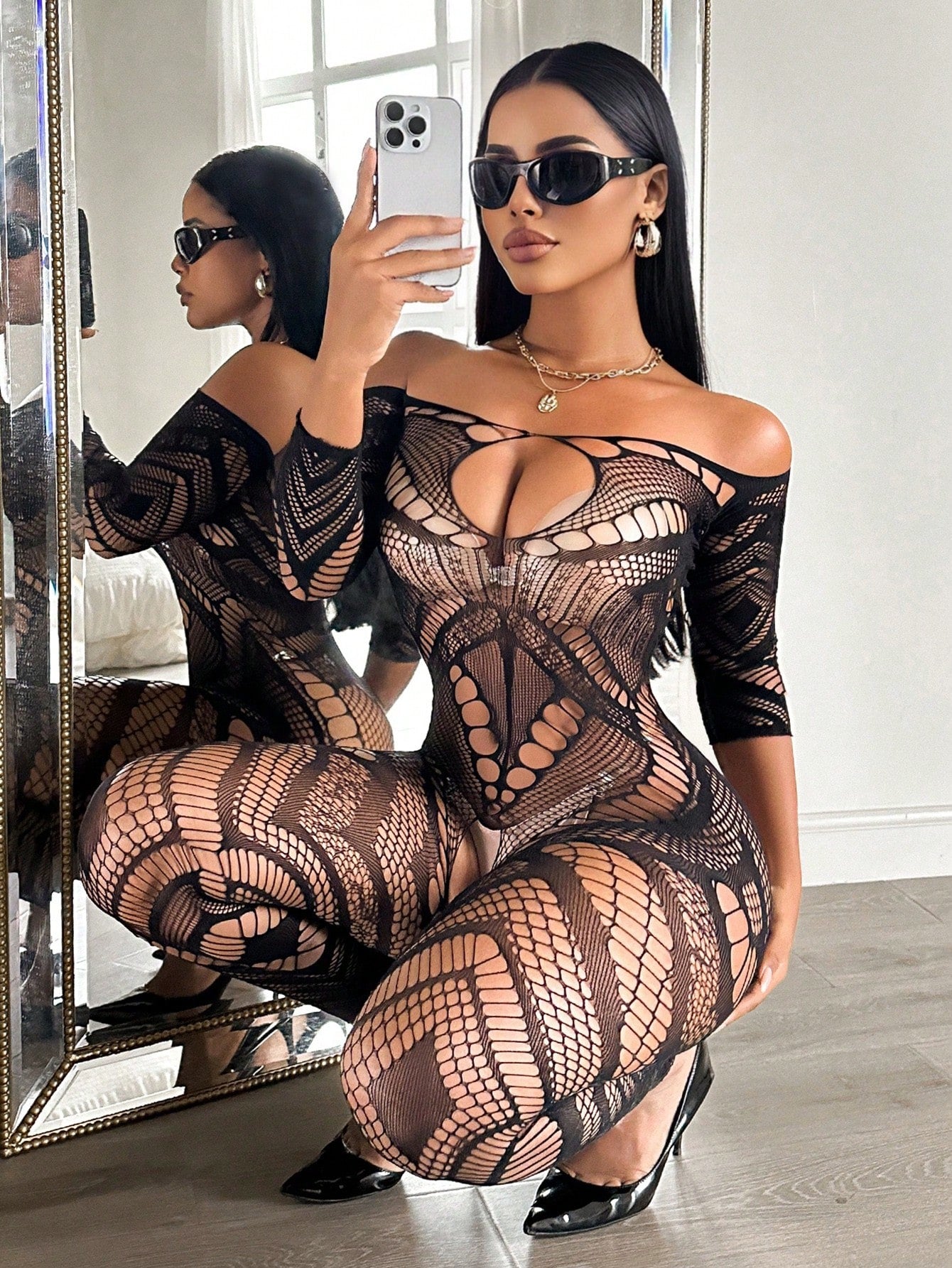 Women's black mesh bodysuit lingerie with hollow-out geometric design, plunge neckline, open back, adjustable straps, and three-quarter sleeves.