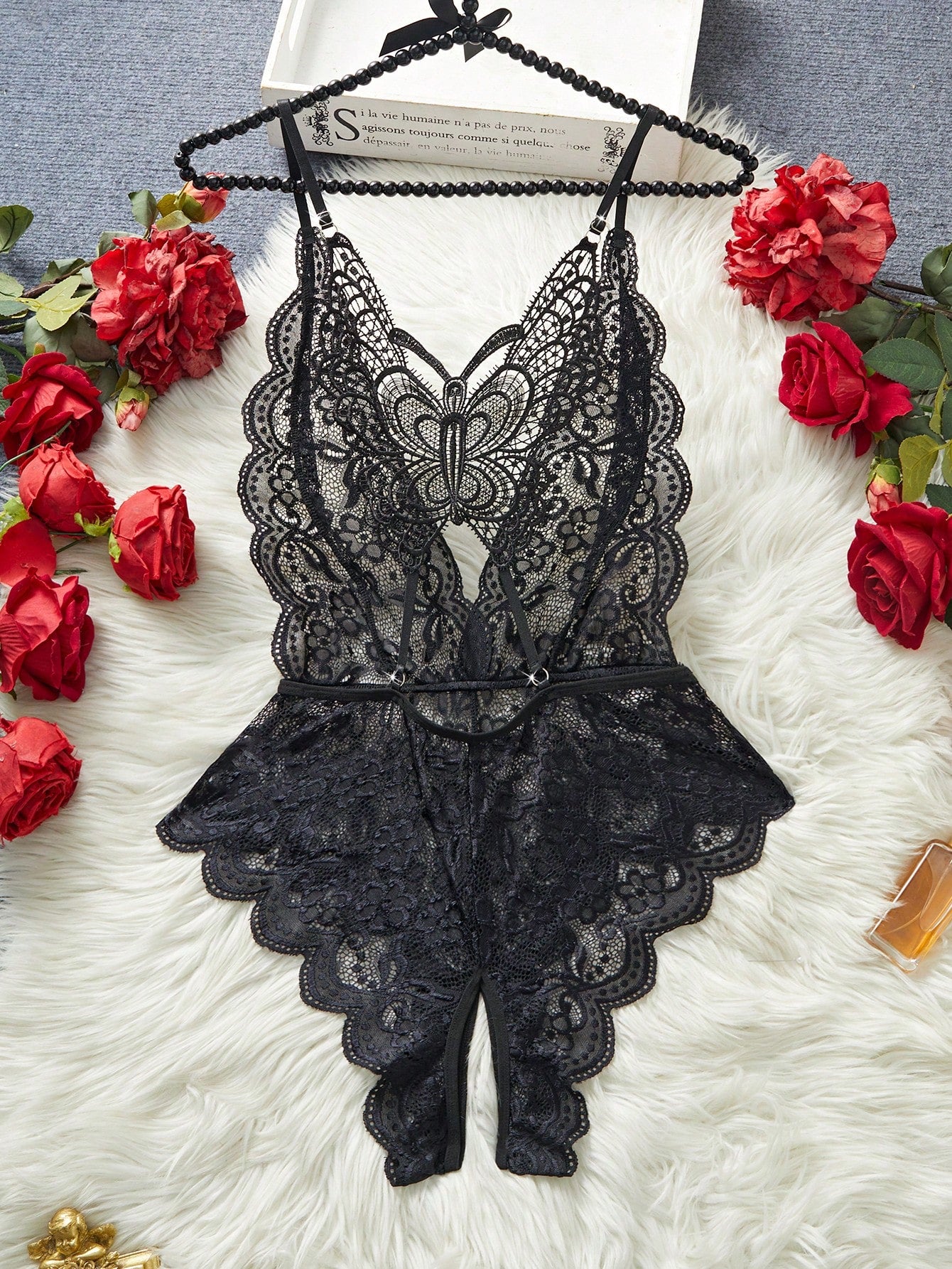 Women's black lace sheer babydoll lingerie with deep V-neck, open-crotch design, adjustable spaghetti straps, wireless bralette top, and butterfly back detail.