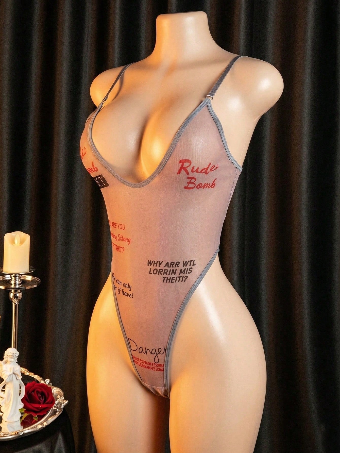 Women's sheer mesh lingerie jumpsuit in grey with a deep V neckline, adjustable straps, thong cut, and high-stretch one-piece design.